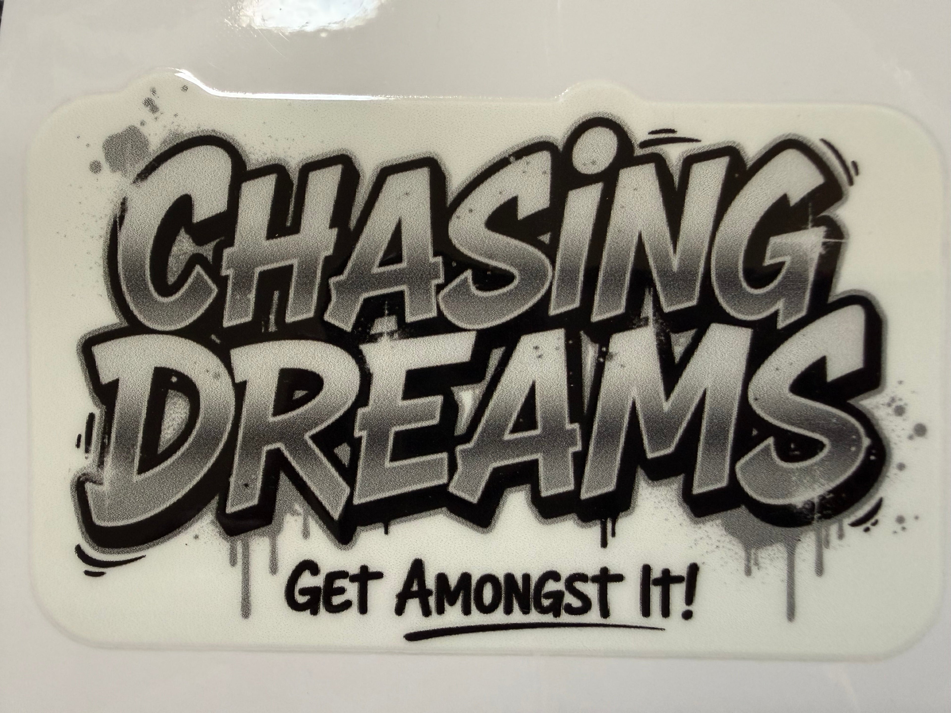 Sticker with 'Chasing Dreams Get Amongst It!' text on a white background